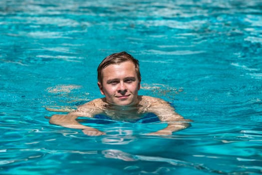 boy enjoys swimming in the outdoor swimming pool