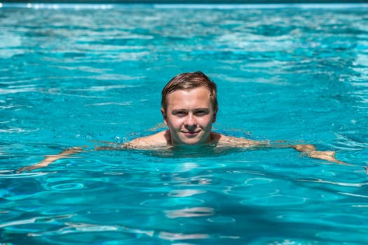 boy enjoys swimming in the outdoor swimming pool