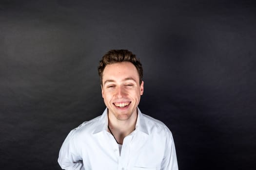 portrait of laughing young man  isolated on black