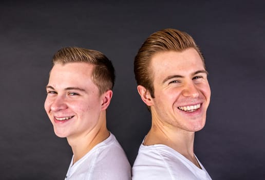 two teenage brothers standing back to back and have fun