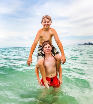 boys having fun in the beautiful clear sea