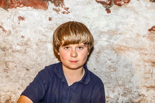 portrait of a cute young boy with old brick background