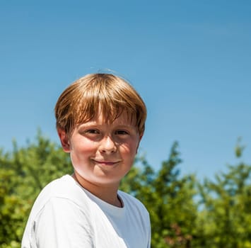 happy boy is smiling and enjoys life under blue sky