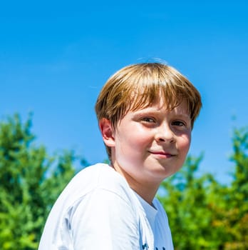 happy boy is smiling and enjoys life under blue sky