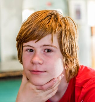 portrait of young teenage boy with long red hair