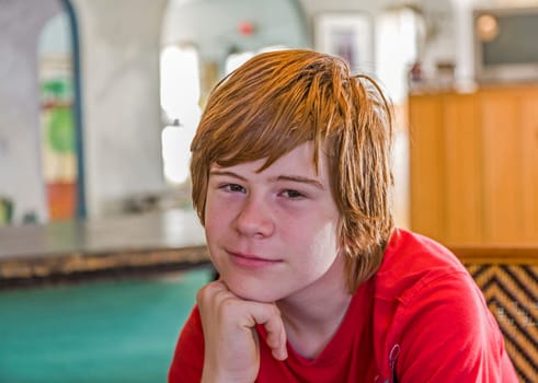 portrait of young teenage boy with long red hair