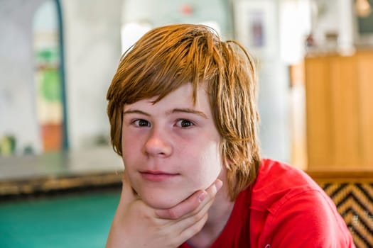 portrait of young teenage boy with long red hair