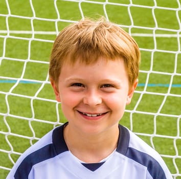 young soccer player poses proudly in his soccer dress