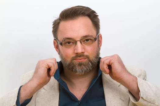 Man straightens his shirt collar - on a light background