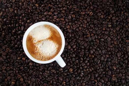 Hot delicious coffee. Espresso cup on coffee beans background.