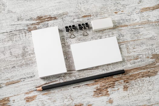 Bank business cards, pencil, eraser, badge and sharpener on vintage wooden table background. Blank stationery and corporate identity template. ID mockup. Mock up for branding identity.