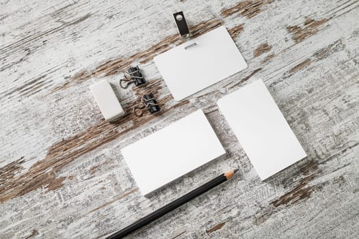 Blank paperwork template for designers. Responsive design mockup. Bank business cards, badge, pencil and eraser on vintage wood table background.