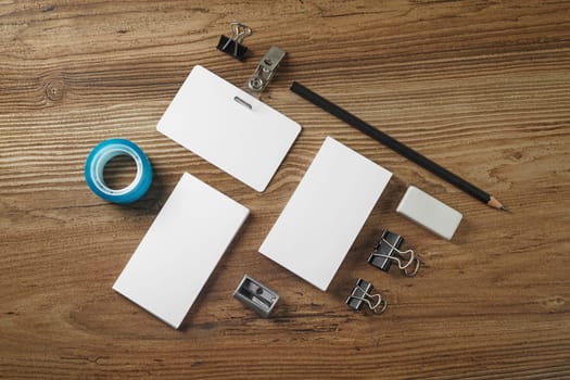 Blank corporate identity template on wooden table background. Photo of blank stationery. Mock up for design portfolios. Top view.