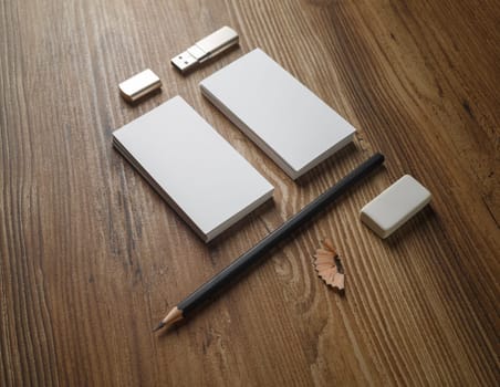 Bank business cards, pencil, eraser and flash drive. Blank paperwork template your design. Responsive design mock up on wooden background.