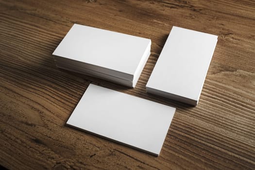 Photo of blank business cards. Blank business cards on wooden table background. Template for ID. Mockup for branding identity.
