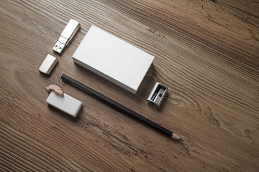 Bank business cards, pencil, eraser, flash drive and sharpener on wooden table background. Blank stationery. Mockup for branding identity for placing your design.