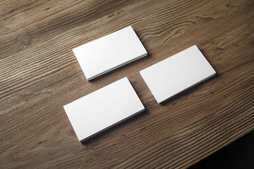 Three stacks of blank business cards on wooden table background. Mock up for branding identity. Blank template for your design.
