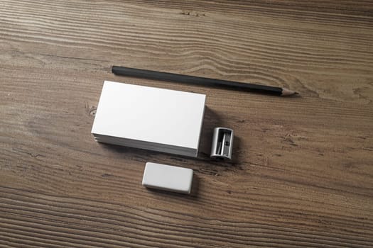 Bank business cards, pencil, eraser and sharpener on wood table background. Mockup for ID. Template for branding identity.