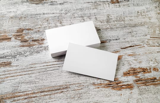 Photo of blank business cards on vintage wooden floor background. Template for your design.