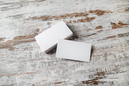 Blank business cards on wood background. Mockup for branding identity. Stack of blank name cards. Blank template for design presentations and portfolios.