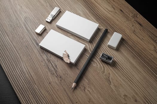 Mockup for ID. Template for branding identity. Bank business cards, pencil, eraser, flash drive and sharpener on wood table background.