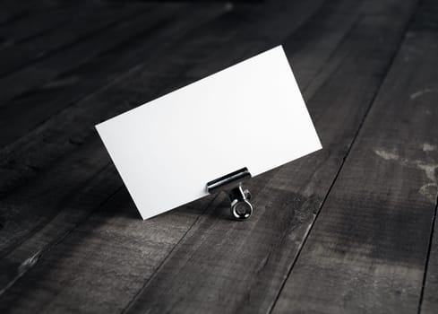 Photo of blank white bussiness card on wood background. Mockup for ID. Template for promotion of corporate identity. Blank name card.