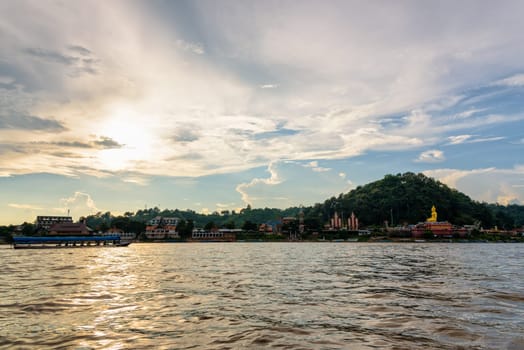Beautiful natural landscape and tourist boat cruising the beauty of the Mekong River coast at sunset in the Golden Triangle Park (Sob Ruak) in Chiang Rai Province, Thailand