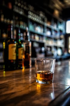 Image of a glass of whiskey on a bar with blurred background