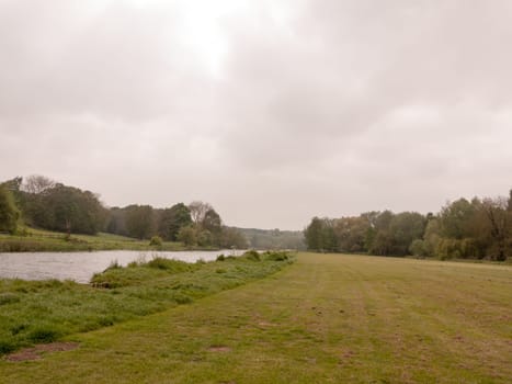 a lovely river running through a park in the uk in spring