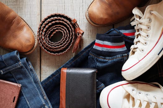Denim clothing and leather accessories on the old wooden.