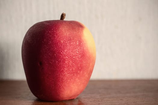 Apple with drops of water on the wooden.