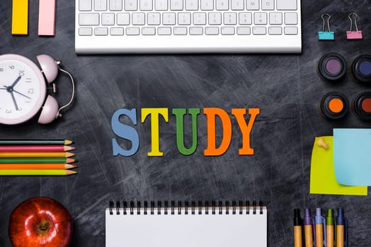 School stationery or office supplies on chalkboard background.