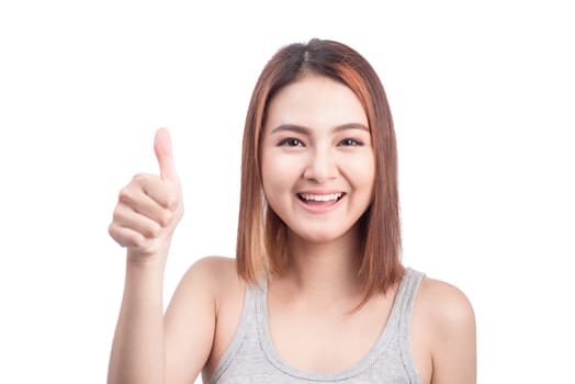 Cheerful lovely girl looking at camera showing thumbs up over white background.