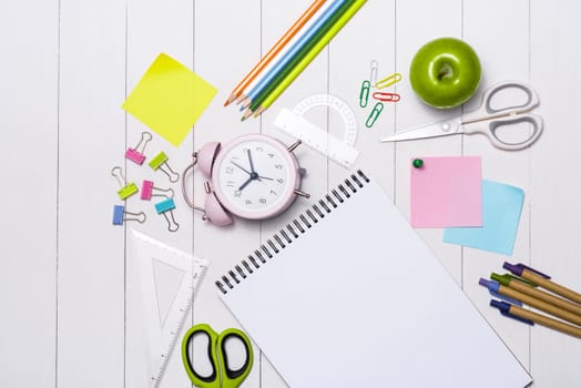 School stationery or office supplies on wood background.