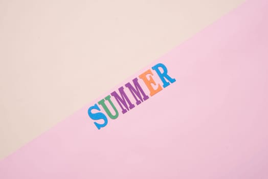 Summer fun written in colorful wooden letters on pastel color background.