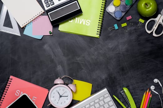School stationery or office supplies on chalkboard background.