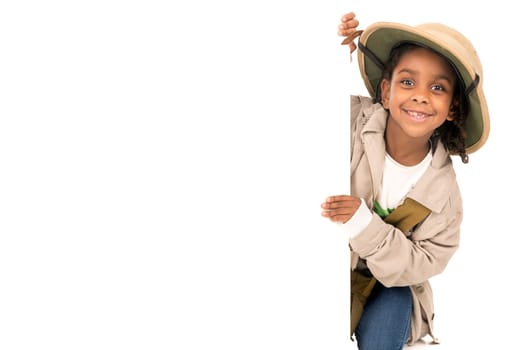 Young girl with Safari clothes behind a white board isolated in white