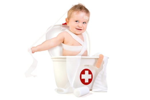 Cute baby boy playing with bandages in a first aid kit box.