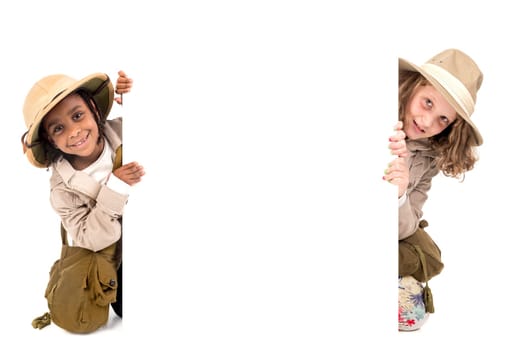 Young girls with Safari clothes behind a white board isolated in white