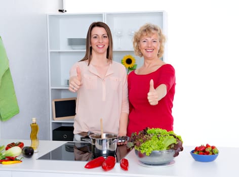 young woman and her mother cooking together in the kitchen