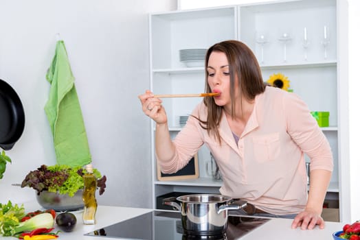 young dark haired woman cooking in a white kitchen