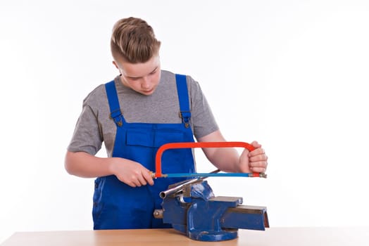 teenager in professional training using hacksaw in front of white background