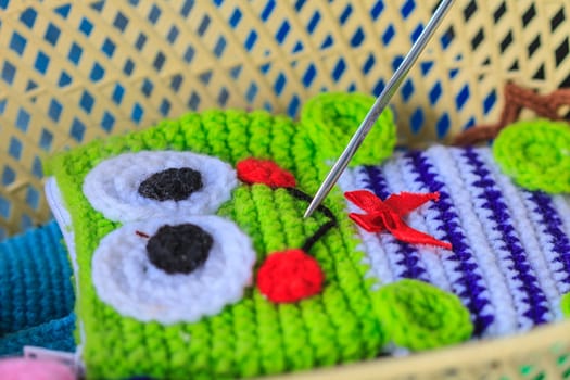 Crochet hook needle on granny square blanket, handmade art and crafts