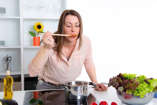 young dark haired woman cooking in a white kitchen