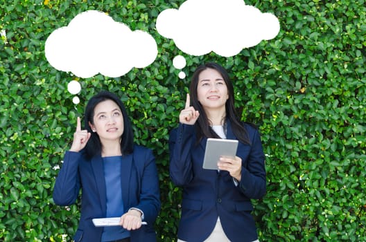 Leader business women concept. Two business women looking up and thinking about goals with blank bubbles.