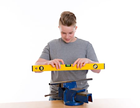 teenager in professional training with spirit level in front of white background
