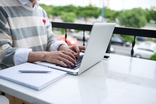 Asian young business man working with laptop atthe city cafe.