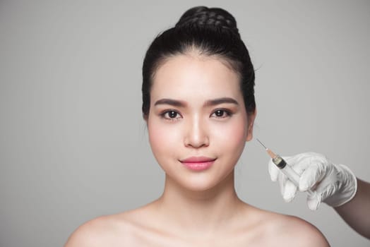Beautiful asian woman gets beauty facial injections. Face aging injection.