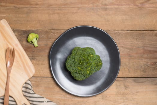 Fresh broccoli in dish on a wooden background