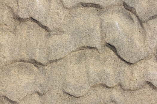 A wavy pattern in beige sand.